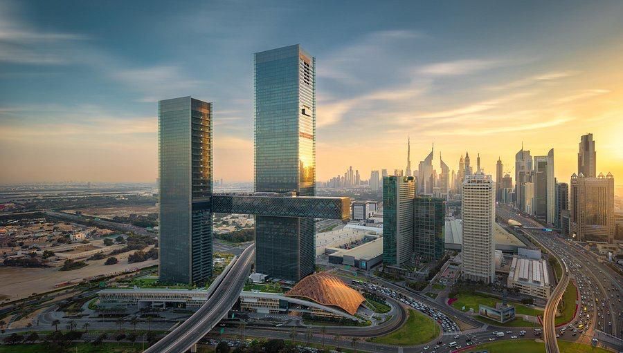 The twin towers of One Za’abeel and the suspended Link spanning between them at sunset, with the Dubai skyline and Burj Khalifa beyond.
