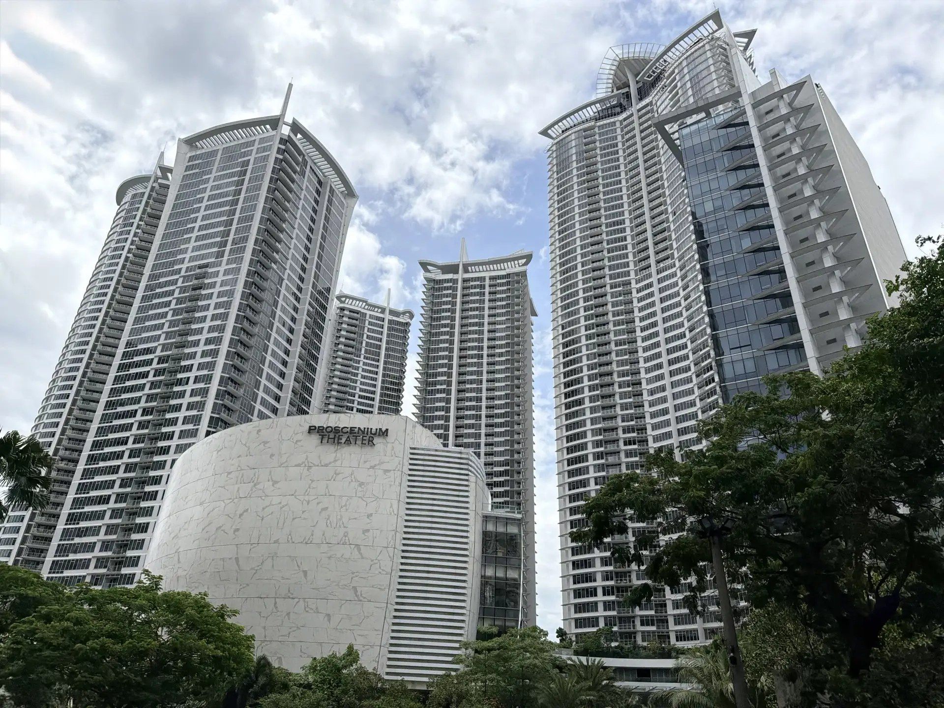 The towers of The Proscenium Residences at Rockwell Center, Makati, rising above the development’s domed theatre against a bright sky.
